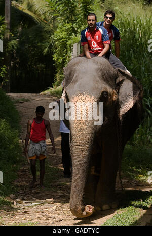 Englands Ravi Bopara und Alastair kochen einen Elefanten bei einem Besuch im Dorf Pinawella in der Nähe von Kandy, Sri Lanka. Stockfoto