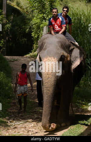 Englands Ravi Bopara und Alastair kochen einen Elefanten bei einem Besuch im Dorf Pinawella in der Nähe von Kandy, Sri Lanka. Stockfoto