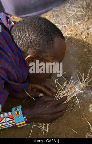 Masai Mann unter Feuer, Amboseli Nationalpark, Kenia, Afrika Stockfoto