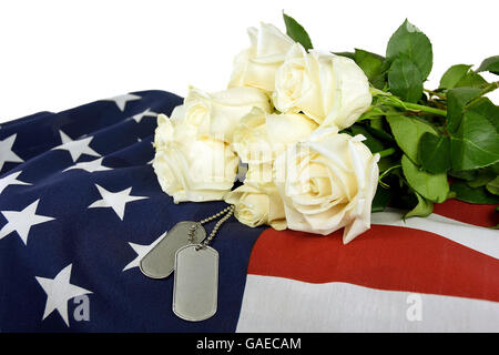 Militärische Erkennungsmarken und weiße rose Strauß auf amerikanische Flagge. Stockfoto