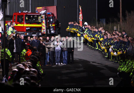 Die Familien beobachten, wie der Leichenwagen, der die Leichen der drei Feuerwehrleute trägt, von Atherstone auf Stour, Warwickshire, vertrieben wird. Stockfoto