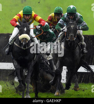 Mond über Miami von Noel Fehily (rechts) geritten, entfliehen Sie dem vorletzten Zaun, um die Verfolgungsjagd der Newspaper der Independent Newspaper zu gewinnen, während der Jockey Paddy Brennan auf der Pferderennbahn Cheltenham einen Sturz von Tramantano hinnimmt. Stockfoto