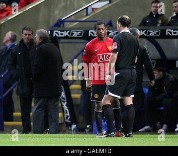 Schiedsrichter Mark Clattenburg hat ein Wort mit Manchesters Patrice Evra als Manager Alex Ferguson wird auf die Tribüne geschickt Stockfoto