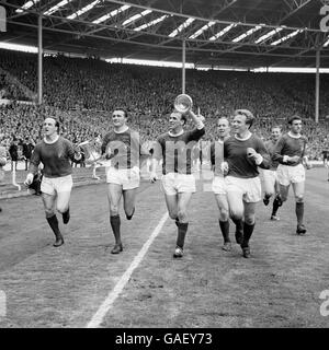 Manchester United (l-r) Maurice Setters, Noel Cantwell, Pat 'Paddy' Crerand, Bobby Charlton, Albert Quixall, David Gaskell (Torwart) und John Giles machen die Ehrenrunde, nachdem Manchester United Leicester City 3-1 im FA Cup-Finale geschlagen hatte. Stockfoto