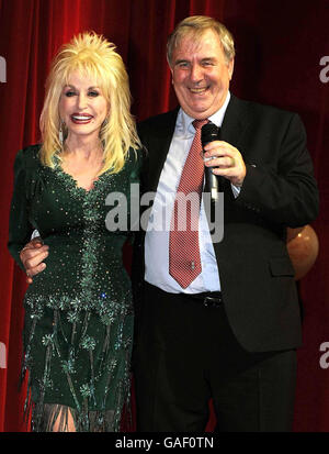 Country-Superstar Dolly Parton mit Ratsmitglied Roger Parker, dem Leiter von RMBC, bei der Einführung der Imagination Library, ihres Kinderalphabetenprogramms im Magna Science Adventure Center in Rotherham, South Yorkshire. Stockfoto