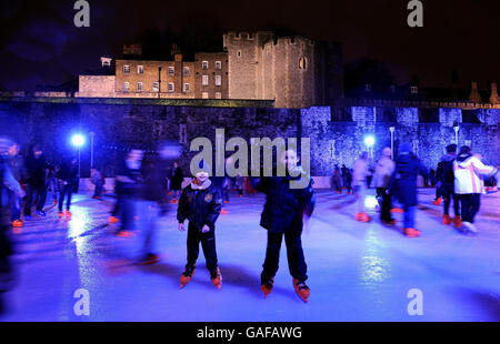 Ein Paar junger Jungen genießt das Eislaufen im Graben des Tower of London an diesem Abend. Stockfoto