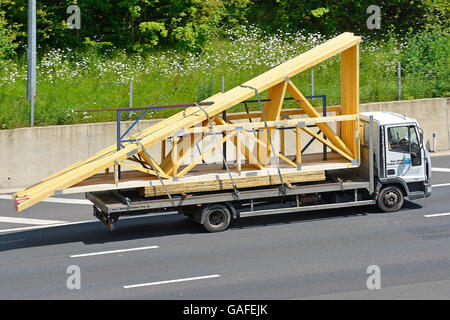 Baustoffe Transport Logistik supply-Chain per LKW beladen mit vormontierten Holz vorgefertigten Dachstühle auf UK-Autobahn Stockfoto