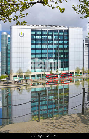 Global Switch Rechenzentrumsanbieter in East India Docks East London England UK mit roten Bussen und Reflektionen in landschaftlich gestaltetem Wasser Stockfoto