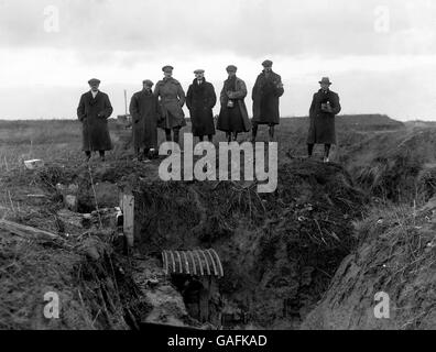 Journalisten und Fotografen verschiedener Nachrichtenagenturen werden in einem verlassenen deutschen Graben, der Teil der Serie von Befestigungen an der Westfront ist, eine Maschinenpistole gezeigt, die als Hindenburglinie bekannt ist. Stockfoto