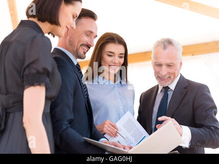 Fröhliche angenehme Kolleginnen und Kollegen diskutieren Projekt Stockfoto