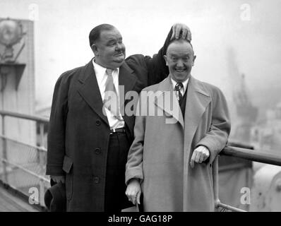 Oliver Hardy kratzt sich am Kopf von Stan Laurel, während das berühmte Paar auf der 'Queen Elizabeth' in Southampton posiert. Es ist ihr erster Besuch im Land seit 1932. Stockfoto