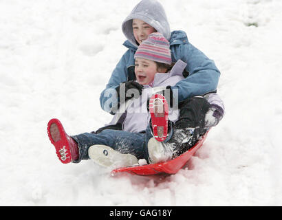 Familien, die den Schnee im Stormont-Anwesen in Belfast genießen. Stockfoto