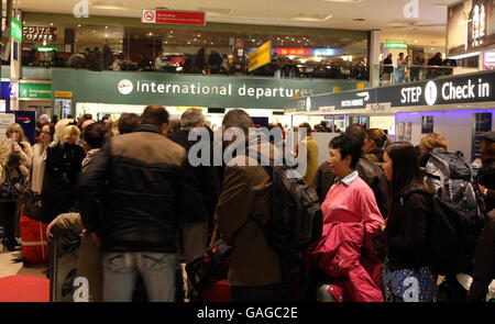 Nebel verzögert den Weihnachtsurlaub. Passagiere stehen im Terminal 1 des Flughafens Heathrow an, nachdem starker Nebel zahlreiche Flugausfälle verursacht hatte. Stockfoto