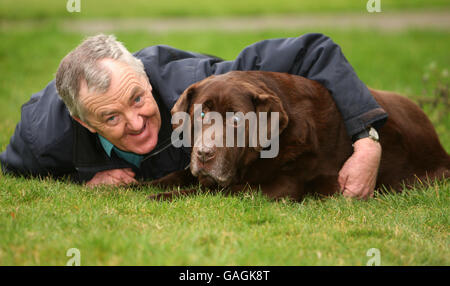 David Benton aus Fordham, Cambridgeshire, mit seinem Chocolate Labrador Rusty, der in weniger als zwei Jahren fünf Steine verloren hat. Stockfoto