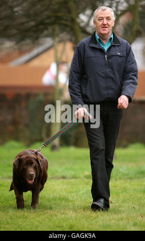 David Benton aus Fordham, Cambridgeshire, mit seinem Chocolate Labrador Rusty, der in weniger als zwei Jahren fünf Steine verloren hat. Stockfoto