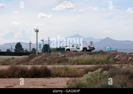 Ein US Border Patrol Agent sitzt in einem Fahrzeug auf der Grenzmauer mit Agua Prieta, Sonora, Mexiko, in Douglas, Arizona, USA. Stockfoto