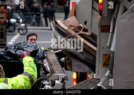 Generisches Bild von Müllsammlern für Westminster Council Entleerung von Behältern und Recycling von Karton in der Nähe des High Court im Zentrum von London. Das Bild zeigt Staubmänner, die Abfall und anderen Hausmüll sammeln. Stockfoto