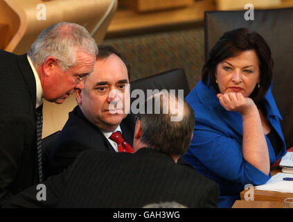 Bruce Crawford spricht mit dem schottischen Erstminister Alex Salmond, dem Finanzminister John Swinney (Rückseite) und dem Bildungsminister Fiona Hyslop im schottischen Parlament während der Haushaltsdebatte in Edinburgh. Stockfoto