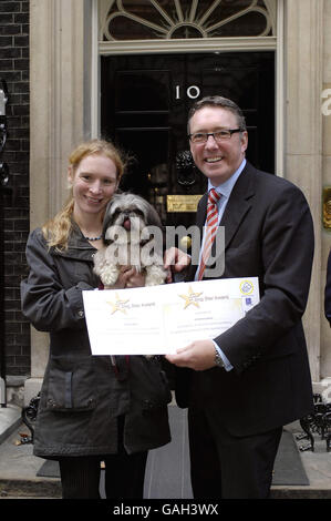 Tony Brown-Griffin, aus Kent, der die Wohltätigkeitsorganisation Support Dogs with Ajay vertritt, trifft einen Beschlagnahmung-Alarmhund auf Phil Hope MP vor der Downing Street 10, London. Stockfoto