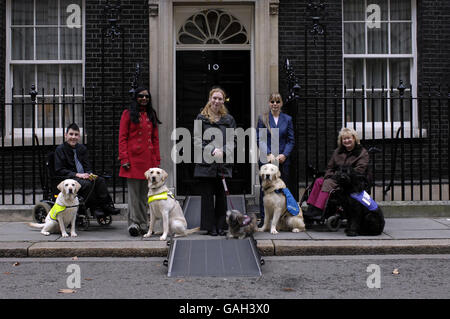 Von links nach rechts, Jack Pegram mit Assistenzhund, Berry, Desi Veeran mit Blindenhund, Zally, Tracy Lewis mit Hörhund Budgie, Tony Brown-Griffin mit Beschlagnahmungsalarm-Hund Ajay, und Claire Graham mit Ulli, einem Hunde-Partner-Hund außerhalb 10 Downing Street, London. Stockfoto