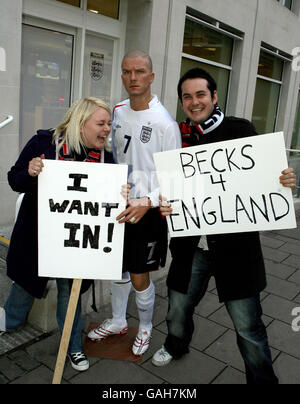 England Fans Lucy Howell, 23, &amp; Kieran Lancini, 27, Beide aus London protestieren vor dem F.A.-Hauptquartier am Soho Square zusammen mit einem Wachsfigurenkabinett von David Beckham von Madame Tussauds, nachdem angekündigt wurde, Beckham sei beim nächsten England Squad in London weggelassen worden. Stockfoto