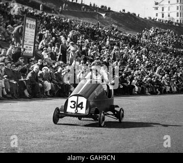 Ein Scout Pedale wütend zu schieben 'Ripple III' über die Ziellinie in der Soap Box Derby von 1954 auf dem Royal Albert Drive, Scarborough statt. Stockfoto