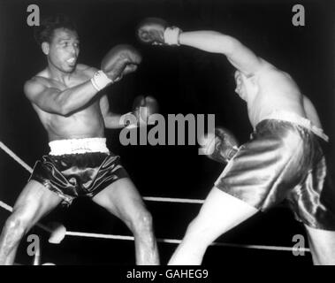 Der 42-jährige ehemalige Weltmeister im Mittelgewicht, Sugar Ray Robinson (l), verblüfft Terry Downes (r) in der ersten Runde ihres Kampfes Stockfoto