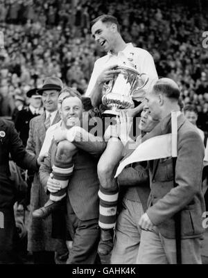 Der siegreiche Kapitän, Tom Smith von Preston North End, zeigt den FA Cup, während er nach dem Spiel triumphierend um das Spielfeld geleitet wird Stockfoto