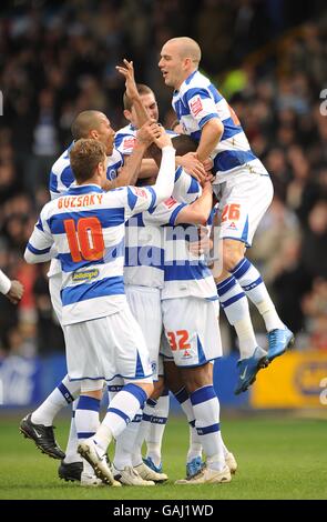 Fußball - Coca-Cola Championship - Queens Park Rangers / Stoke City - Loftus Road. Mikele Leigertwood (Mitte) von Queens Park Rangers wird von Rams-Freunden überkompensiert, nachdem er das Eröffnungstreffer erzielt hat. Stockfoto