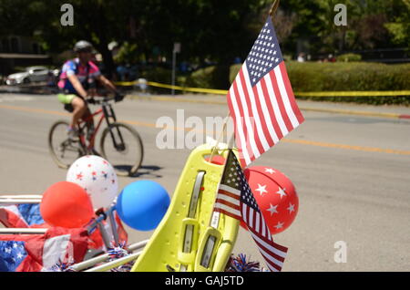 Ein Radfahrer fährt vorbei an einem dekorierten Fahrrad nach der Fourth Of July Parade Ross, Kalifornien in Marin County. Stockfoto