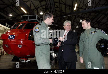 Verteidigungsminister des Browne spricht mit Piloten Leutnant James Bullock (links) und Zweiter im Kommando bei HMS Gannet Leutnant Martin Lanni (rechts) während des Besuchs des Ministers bei der geschäftigsten Such- und Rettungshubschrauberstation der Royal Navy, HMS Gannet in Prestwick. Stockfoto