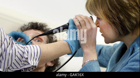 Die schottische Gesundheitsministerin Nicola Sturgeon (rechts) schaut während einer Nasenendoskopie der Patientin Alisa Evans während eines Besuchs im St. John's Hospital in Livingston, Schottland, durch ein Endoskop. Stockfoto