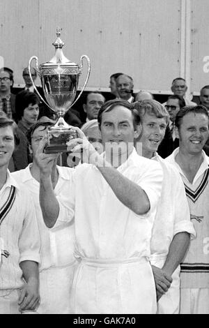 Leicestershire-Kapitän Ray Illingworth, umgeben von seinen triumphierten Teamkollegen, hält den Benson und Hedges Cup nach dem Sieg seines Teams über fünf Wicket in die Höhe Stockfoto