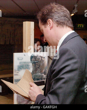 David Cameron, Vorsitzender der britischen Konservativen Partei, liest ein handgeschriebenes Tagebuch, während er bei einer Tour durch die Hellman-Ausstellung im National Army Museum, London, in der Nähe eines Modells einer britischen Armeemörtelposition in der Provinz Hellman, Afghanistan, steht. Stockfoto