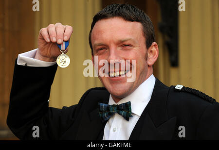 Der Terrorist John Smeaton am Flughafen Glasgow greift nach dem Sammeln der Gallanterie-Medaille seiner Königin im Buckingham Palace, London, an. Stockfoto