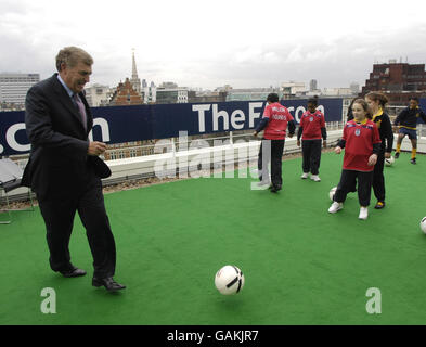 Sir Trevor Brooking der FA mit Kindern der St John's School in Fulham auf dem Dach des FA-Hauptquartiers in Soho Square, London, um eine Investition von 200 Millionen in den Breitenfußball anzukündigen. Stockfoto