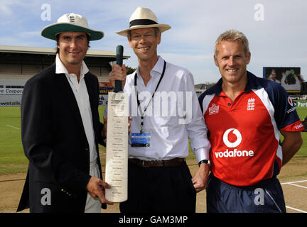 England-Kapitän Michael Vaughan überreicht Christopher Martin-Jenkins, Cricket-Korrespondent der Times, der nach 35 Jahren in den Ruhestand geht, mit Trainer Peter Moores (rechts) vor dem Start des 3. Tests zwischen England und Neuseeland im McLean Park, Napier, Neuseeland, eine besondere Fledermaus. Stockfoto