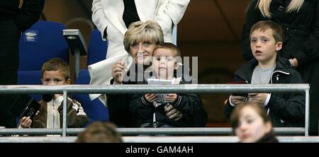 Die Familie Beckham, (von links nach rechts) seine Kinder Romeo, Cruz und Brooklyn spielen Computer, während Davids Mutter Sandra von der Tribüne aus mit ihnen schaut Stockfoto