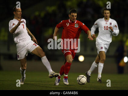 Der walisische Jason Koumas überspringt die Herausforderung von Jeff Strasser aus Luxemburg beim internationalen Spiel im Stade Josy Barthel in Luxemburg. Stockfoto