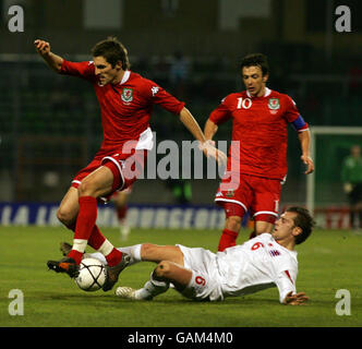 Der Waliser Sam Ricketts überspringt das Tackle von Rene Peters aus Luxemburg während des Internationalen Spiels im Stade Josy Barthel in Luxemburg. Stockfoto