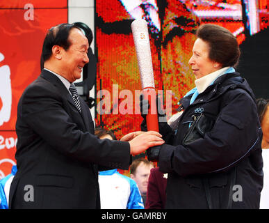 Die Prinzessin Royal, Prinzessin Anne, nimmt die olympische Fackel vom Exekutivvizepräsidenten des Pekinger Organisationskomitees, Jiang Xiaoyu, während des großen Finales des olympischen Fackellaufs in der O2 Arena in Greenwich entgegen. Stockfoto