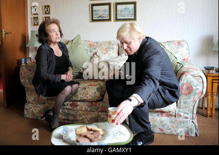 Der Kandidat des Londoner Bürgermeisters Boris Johnson spricht mit Frau Audrey Terrey, während er Opfer von Verbrechen in Croydon, Süd-London, besucht. Stockfoto