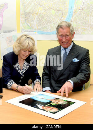 Der Prinz von Wales und die Herzogin von Cornwall unterschreiben ein Foto während eines Besuchs der Charing Cross Polizeistation in London, um Beamte und Mitarbeiter zu treffen und die von der Polizei verwendete Ausrüstung zu sehen. Stockfoto