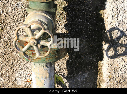 rostigen alten Wasserhahn und den Wasserschlauch im Garten des verlassenen Hauses Stockfoto