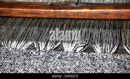 alte hölzerne Webstuhl für die Produktion der Stoffe in der alten Textilindustrie mit der schwarzen und weißen Farbe Wollfäden Stockfoto