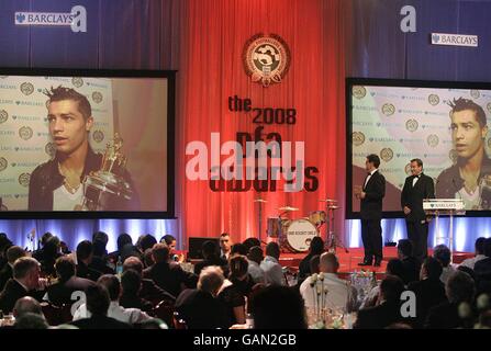 England Manager Fabio Capello und Jeff Stelling auf der Bühne als PFA Players Player of the Year Preisträger Cristiano Ronaldo hält eine Rede per Video bei den PFA Player of the Year Awards 2008 im Grosvenor House Hotel, London. Stockfoto