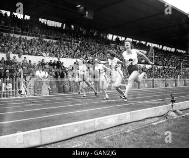 Die Australier Marlene Mathews (r) gewinnt Gold im 110-Yds-Finale der Frauen von Teamkollege Betty Cuthbert (l, 4.) und der britischen Heather Armitage (2. R, Silber) und Madelaine Weston (3. R, Bronze) Stockfoto