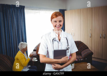 Porträt einer lächelnden Krankenschwester mit senior Stockfoto
