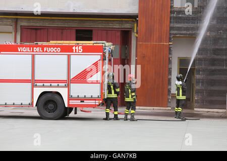 italienische Feuerwehrauto vor dem brennenden Gebäude hochgezogen Stockfoto