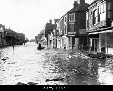 Anstelle von Verkehr und Fußgängern hält ein einsames Boot die Bühne in der Hauptstraße des überfluteten Mablethorpe, Lincolnshire, nach der Zwangsevakuierung in den verheerenden und weit verbreiteten Überschwemmungen. Stockfoto